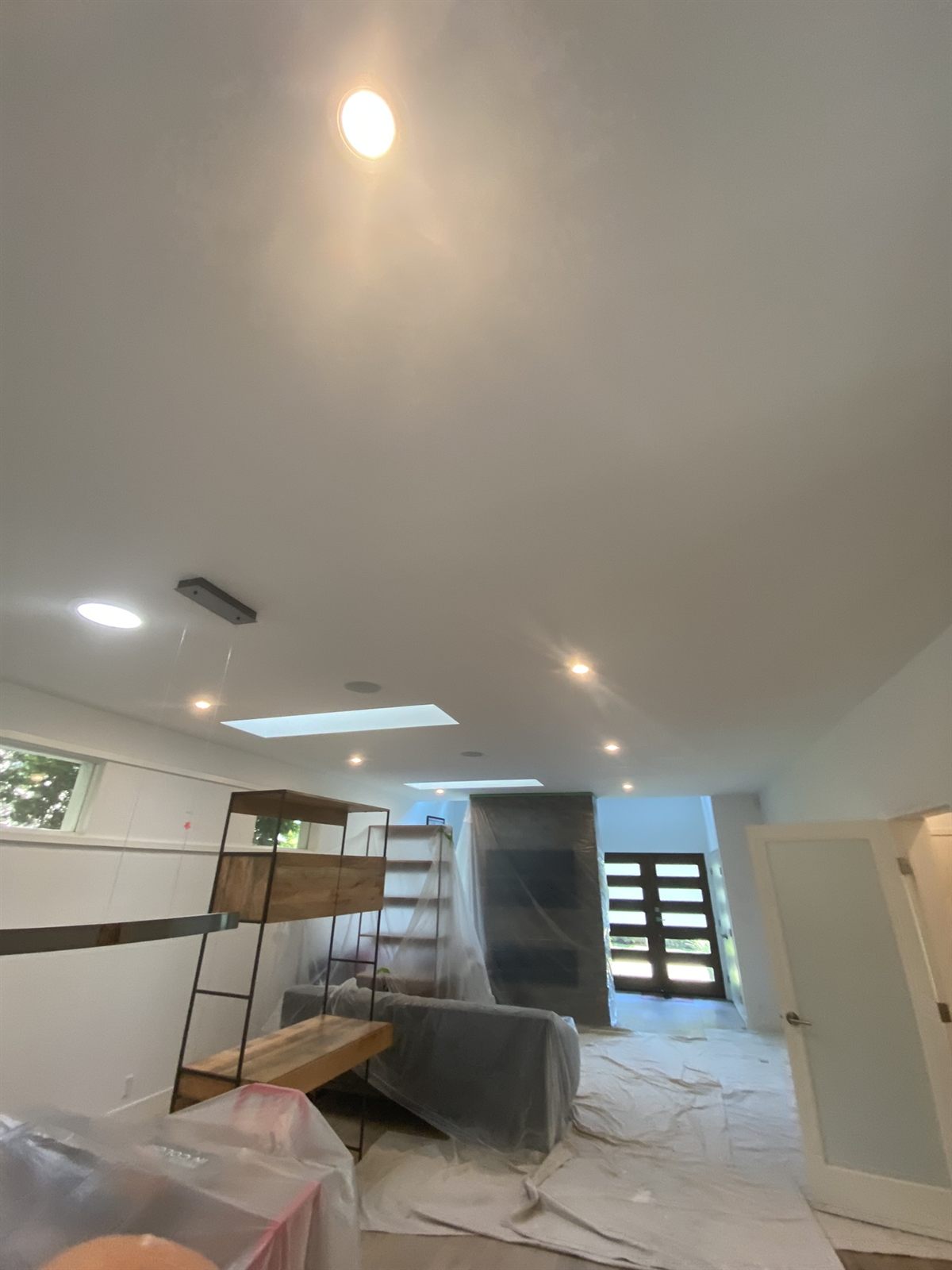 Interior repaint in progress with floors and furniture protected