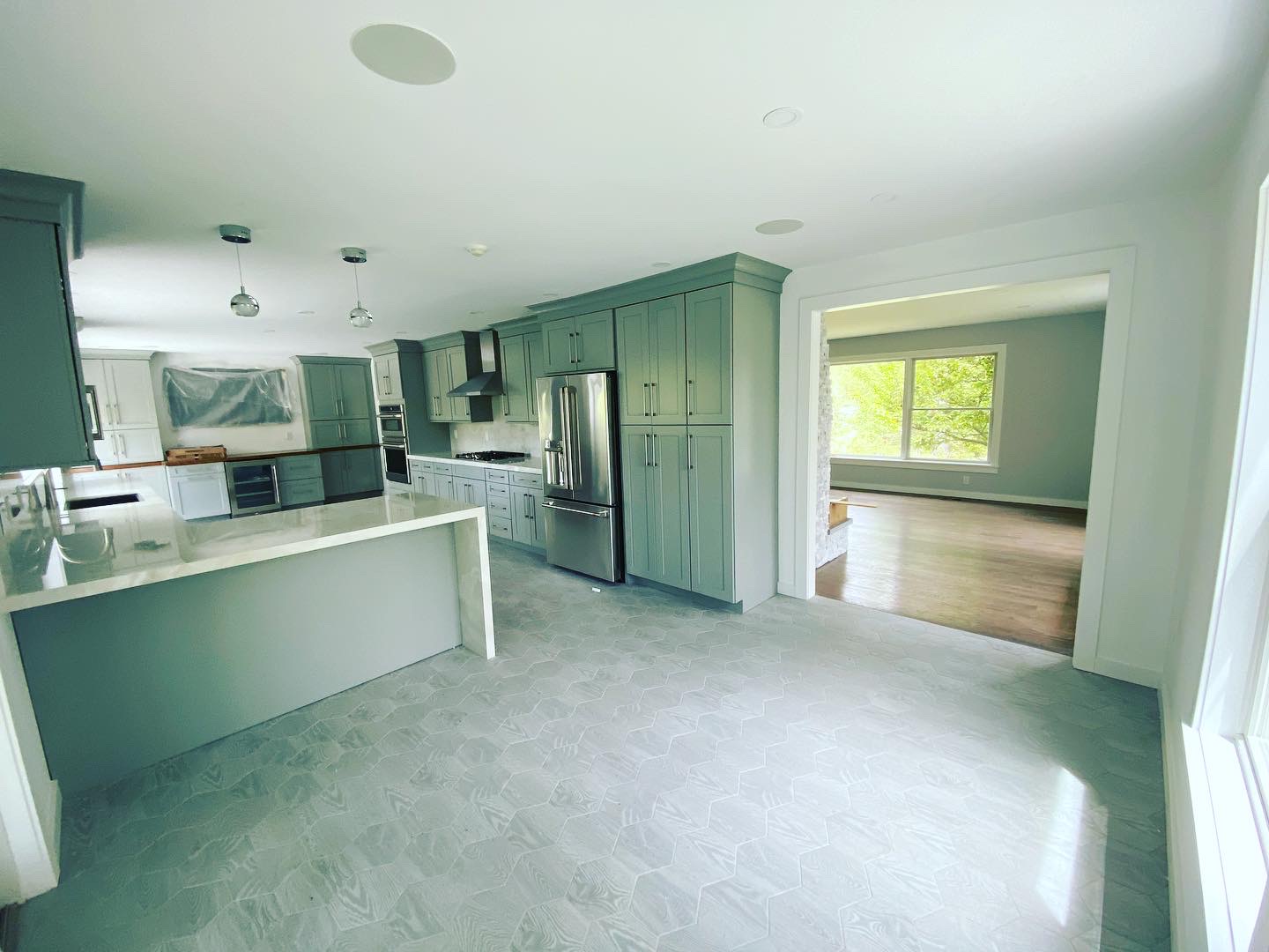 Sage green kitchen with freshly painted cabinets and trim